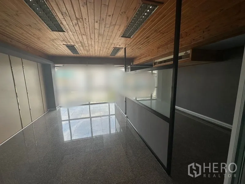 Office Space for rent - Long workspace with timber ceiling, recessed lighting and partial glass divider.