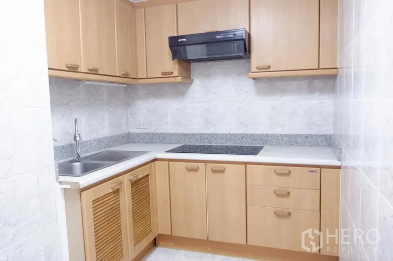 公寓 出租在Khlong Toei, Bangkok - 封闭式厨房，浅木柜体、电磁炉、抽油烟机与水槽