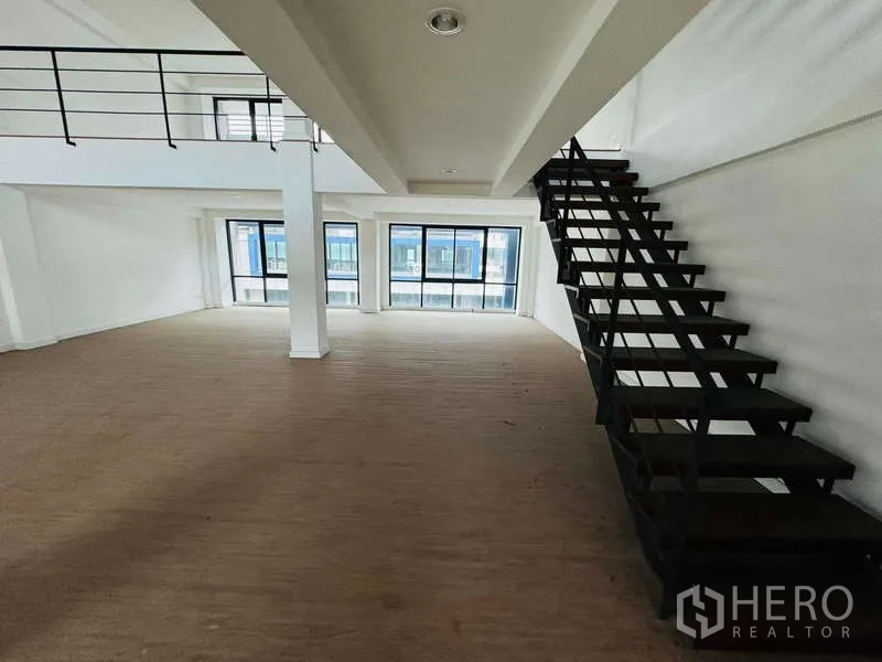 Home Office for rent in Bueng Kum, Bangkok - Open loft area with three large front windows and a floating steel stairway.