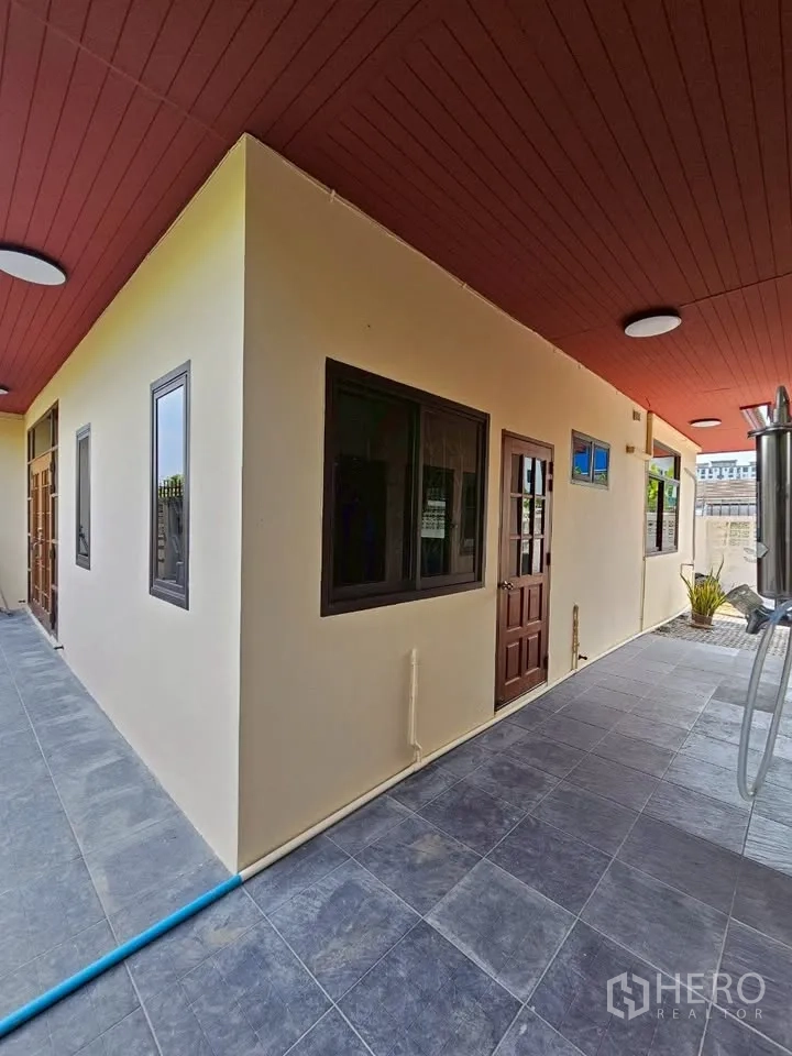 สำนักงานที่บ้าน for rent in Wang Thonglang, Bangkok - ทางเดินด้านข้างมีหลังคา ฝ้าเพดานสีแดง พื้นกระเบื้องเทา หน้าต่างและประตูไม้