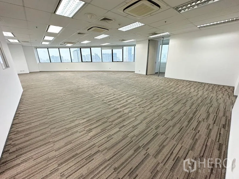 สำนักงาน ให้เช่าในWatthana, Bangkok - พื้นที่สำนักงานแบบเปิดโล่ง ปูพรม ฝ้าเพดานพร้อมไฟ และหน้าต่างบานกว้างมองเห็นวิวเมืองกรุงเทพฯ