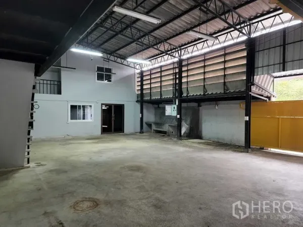 货栈 出租在Chatuchak, Bangkok - 宽敞装卸区，配有水槽、电箱与部分开启的黄色大门。