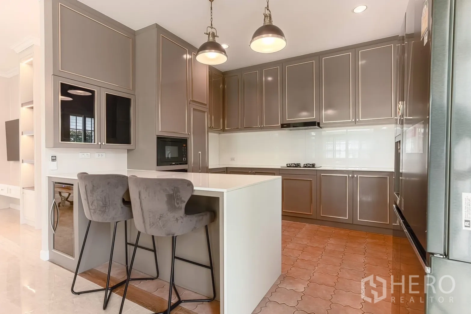 Detached House for rent in Bang Na, Bangkok - Modern kitchen with island breakfast bar, pendant lights, and gray shaker cabinets.