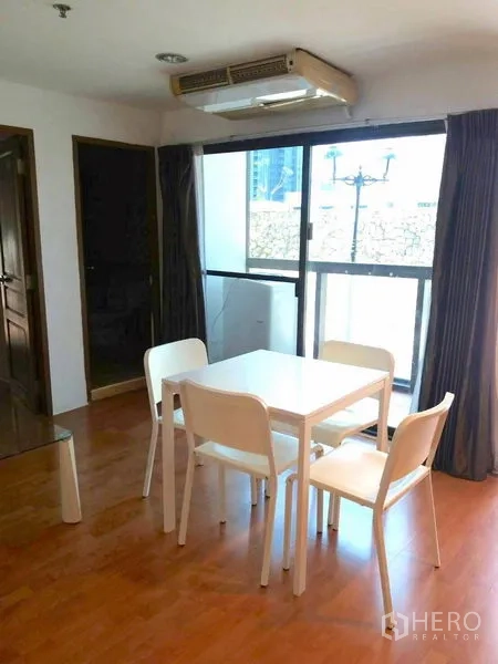 คอนโด ให้เช่าในWatthana, Bangkok - มุมรับประทานอาหารโต๊ะสีขาว 4 ที่นั่ง ติดประตูกระจกบานเลื่อนออกไประเบียงเล็ก.