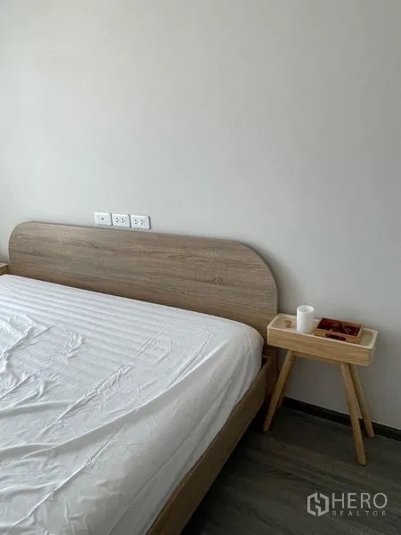 คอนโด ให้เช่า - ส่วนหัวเตียงไม้สไตล์มินิมอลและโต๊ะข้างเล็ก