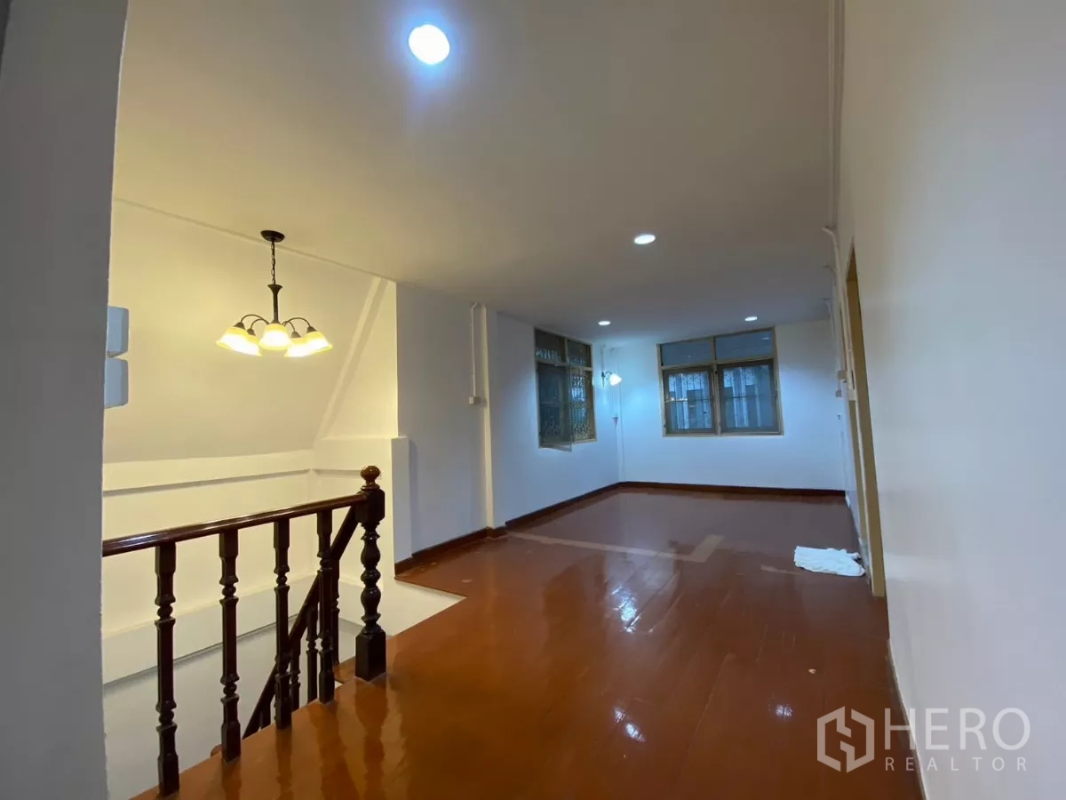 Detached House for rent in Bang Na, Bangkok - Upper-floor landing and family area with wood floors and multiple windows with security grilles.