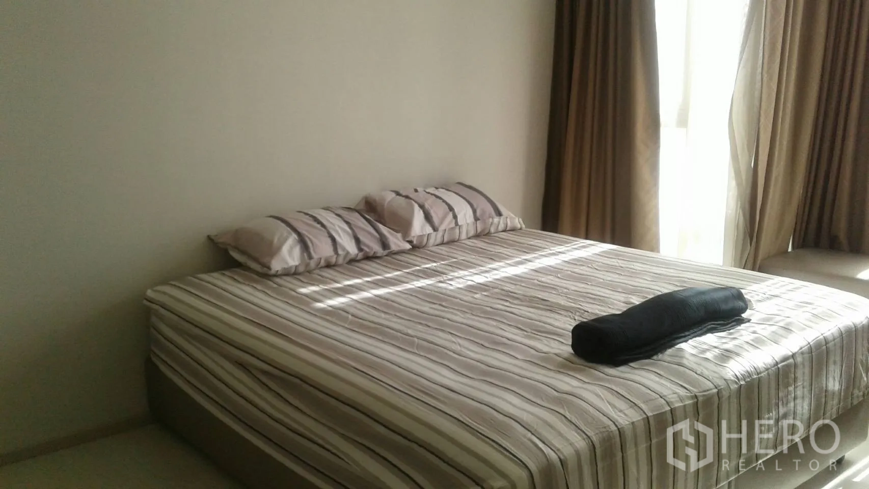 公寓 出租在Khlong Toei, Bangkok - 温馨卧室，大床配条纹床品与落地窗帘。