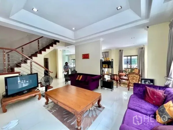 独立式住宅 出租在Prawet, Bangkok - 家庭起居区，层顶吊顶设计，紫色沙发与楼梯。