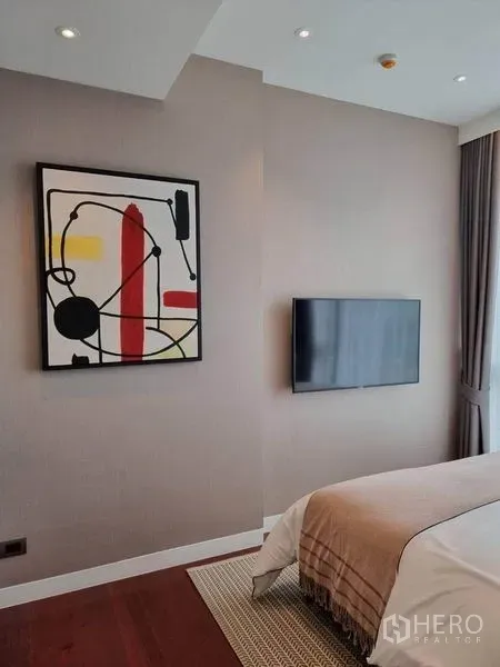 公寓 出租在Watthana, Bangkok - 卧室配墙挂电视与抽象画，大窗搭配窗帘，风格现代。