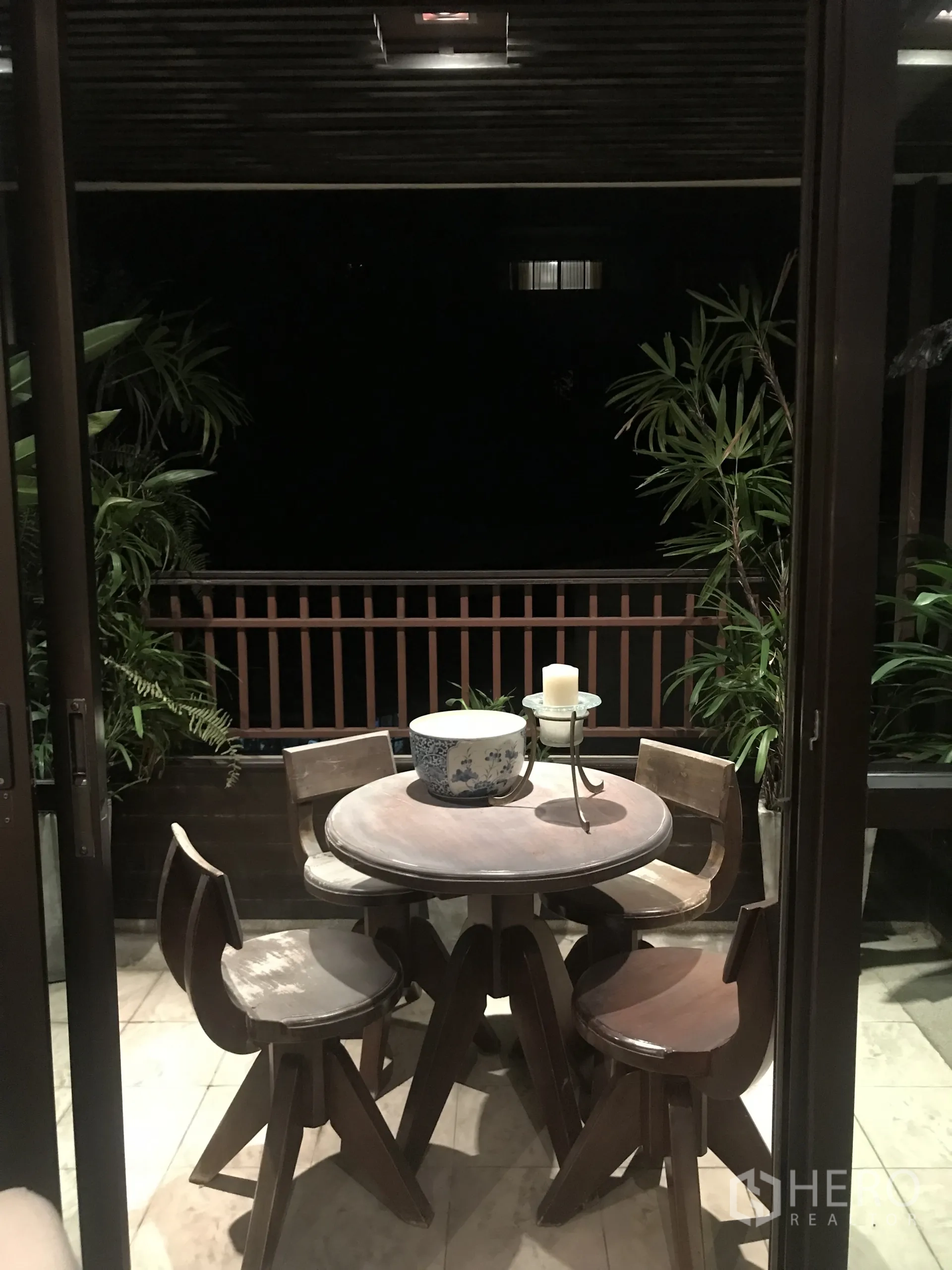Condominium for sale in Yan Nawa, Bangkok - Covered balcony terrace with round table, four chairs and potted greenery.