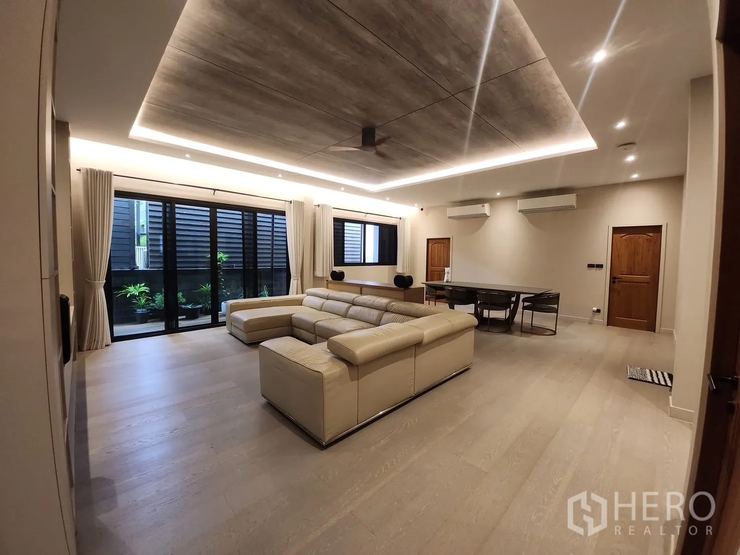 Detached House for rent in Bang Phli, Samut Prakan - Open living and dining area with floor-to-ceiling windows and LED cove ceiling.