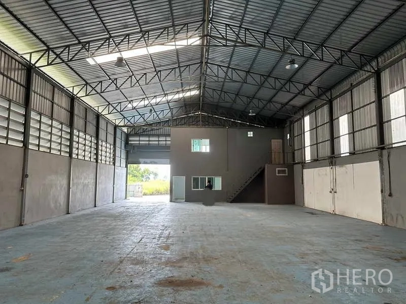 货栈 出租在Pathum Thani - 室内高挑钢桁架屋顶，带夹层办公室和楼梯的宽敞仓库