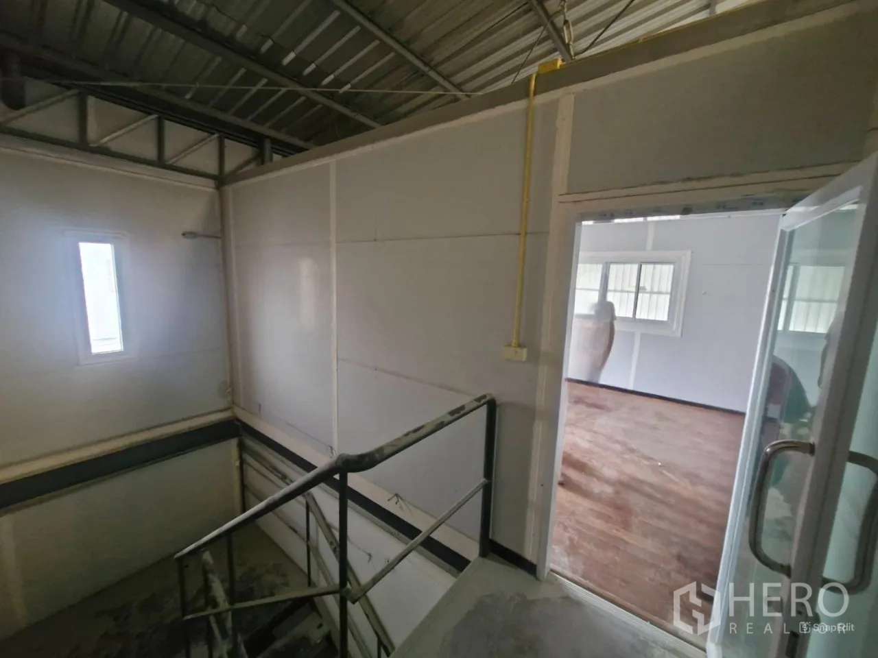 คลังสินค้า ให้เช่าในThung Khru, Bangkok - บันไดขึ้นออฟฟิศชั้นลอยผนังสีขาวใต้หลังคาเมทัลชีท