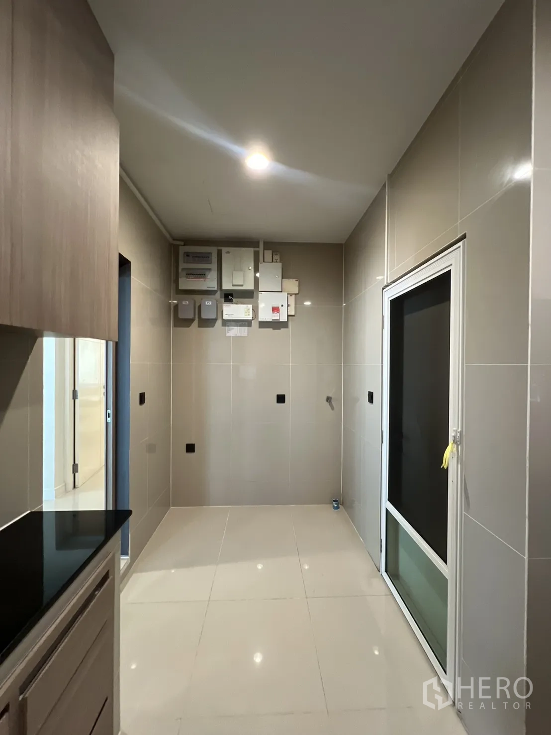 独立式住宅 出售在Bang Kapi, Bangkok - 厨房外的家务区，瓷砖墙面与外门。