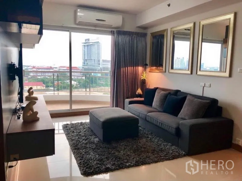 คอนโด ให้เช่าในBangkok - มุมนั่งเล่นอบอุ่นด้วยโซฟาออตโตมันและพรม เชื่อมระเบียงที่มองเห็นวิวเมืองกว้าง