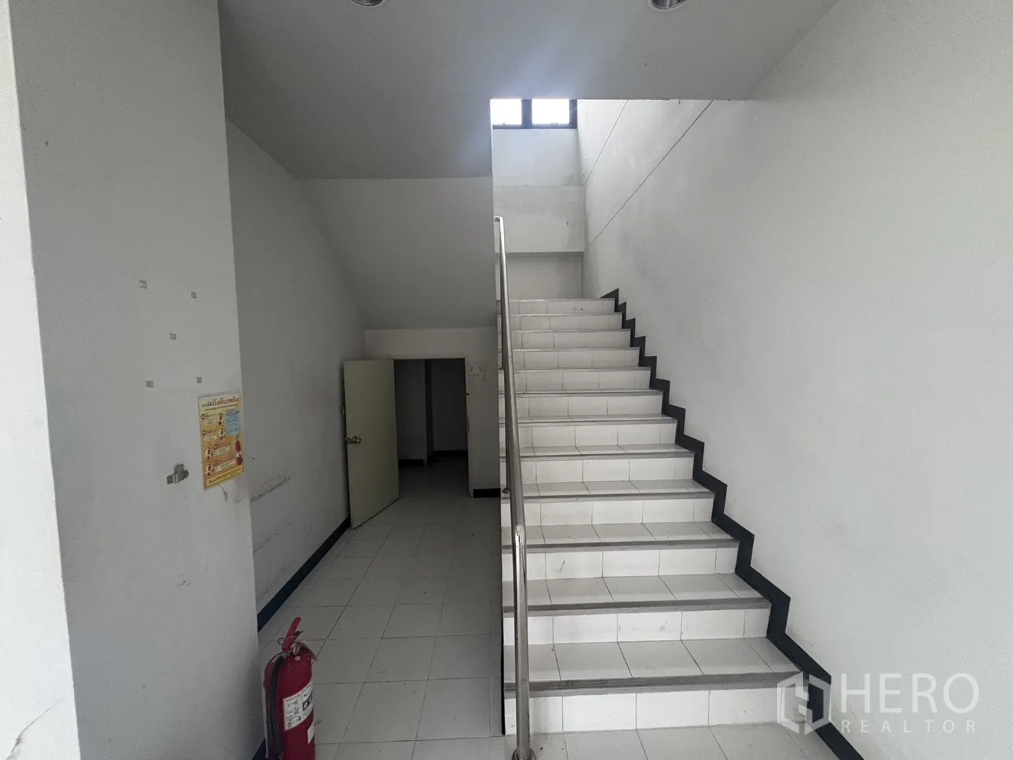 Factory for rent or sale in Samut Prakan - Long office workspace with interior windows overlooking the factory floor.