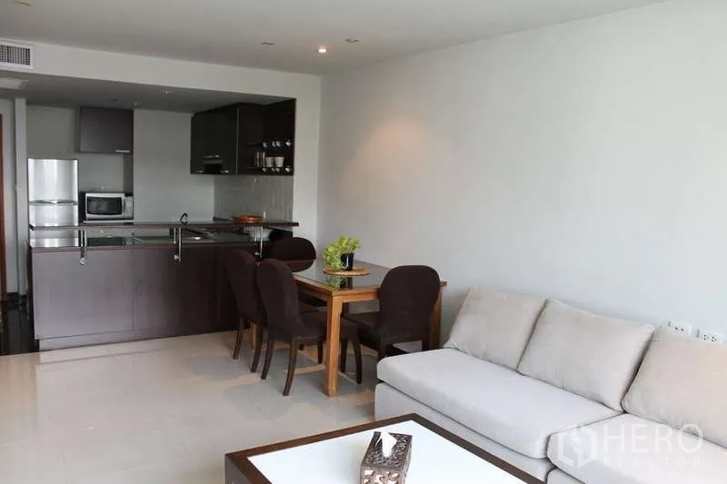 คอนโด ให้เช่าในSathon, Bangkok - พื้นที่นั่งเล่นและรับประทานอาหารแบบโอเพ่น พร้อมโซฟา โต๊ะสี่ที่นั่ง และครัวไม้โทนเข้มในคอนโดสมัยใหม่