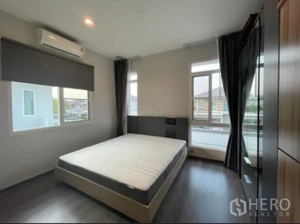 บ้าน ให้เช่าในLat Krabang, Bangkok - ห้องนอนสว่างพร้อมเตียงควีน พื้นไม้ หน้าต่างบานใหญ่ และผ้าม่านทึบ