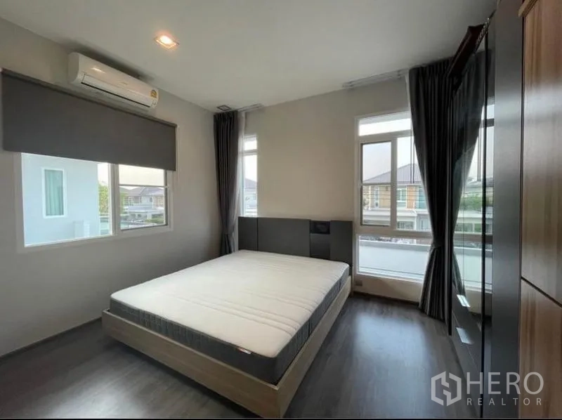 บ้าน ให้เช่าในLat Krabang, Bangkok - ห้องนอนสว่างพร้อมเตียงควีน พื้นไม้ หน้าต่างบานใหญ่ และผ้าม่านทึบ