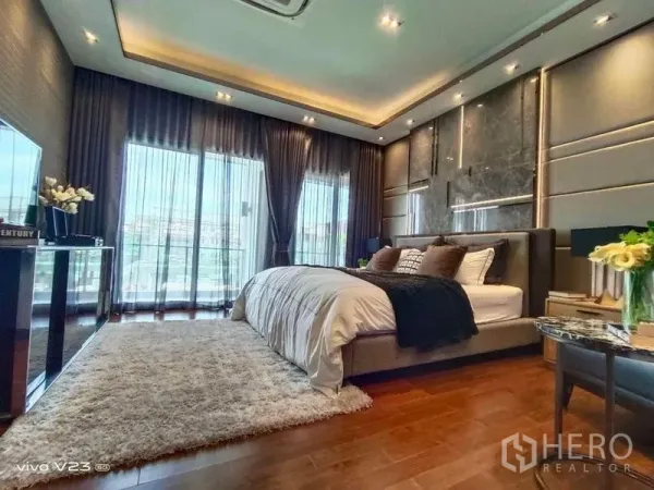 Detached House for sale in Wang Thonglang, Bangkok - Luxurious master bedroom with balcony access, floor-to-ceiling curtains and warm wood flooring.