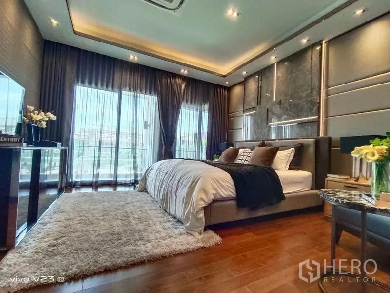 Detached House for sale in Wang Thonglang, Bangkok - Luxurious master bedroom with balcony access, floor-to-ceiling curtains and warm wood flooring.