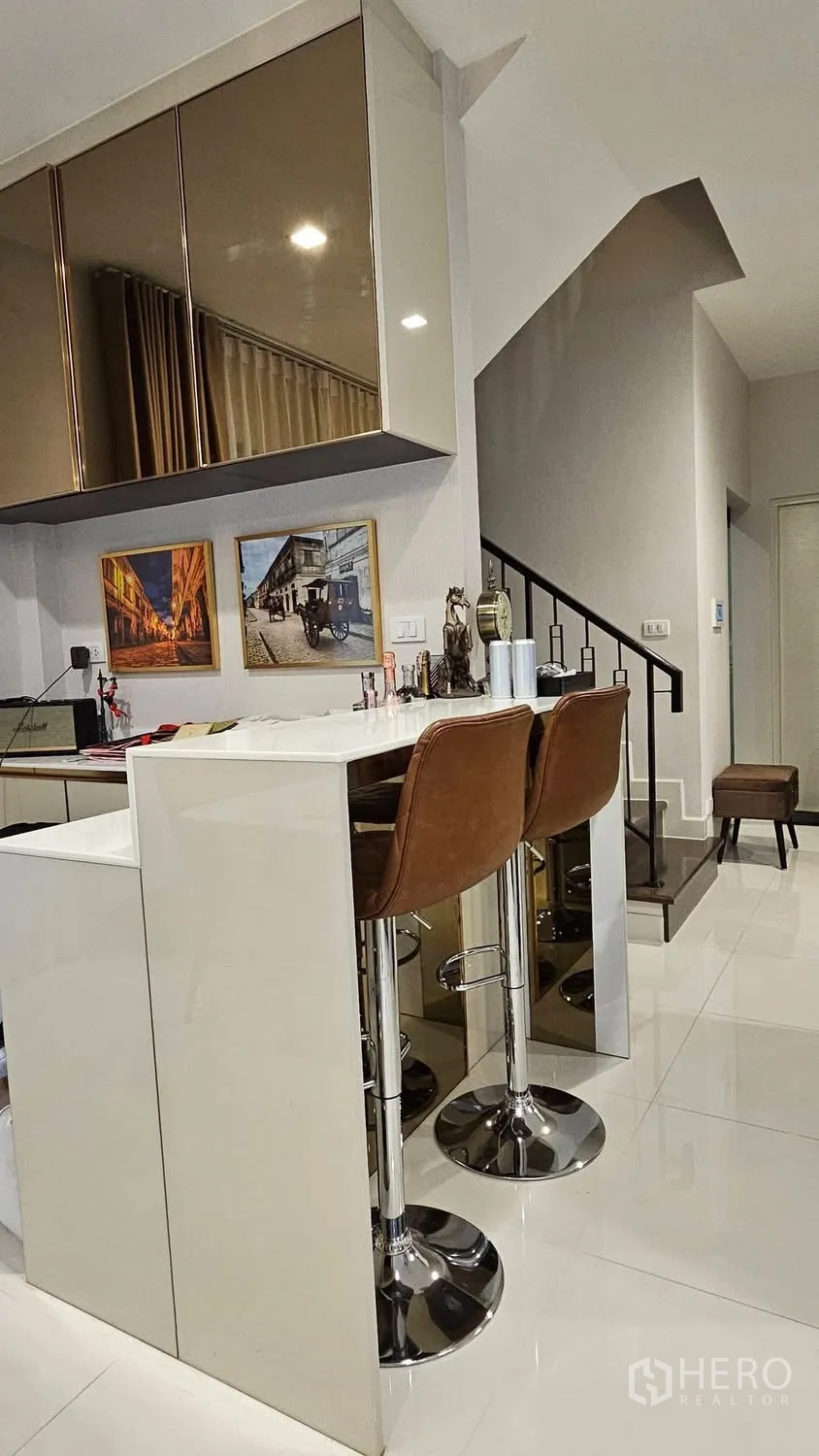 บ้านเดี่ยว for rent in Saphan Sung, Bangkok - เคาน์เตอร์บาร์ท็อปสีขาวพร้อมสตูลสองตัว ใกล้บันได.