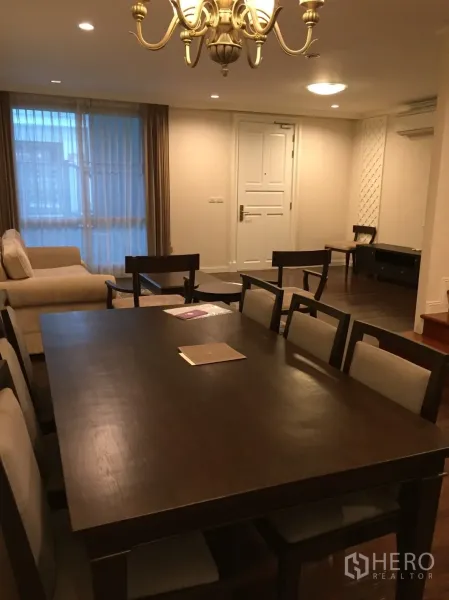 公寓 出售在Huai Khwang, Bangkok - 温馨餐客一体空间，深色木餐桌、吊灯、沙发与落地纱帘，曼谷两卧公寓。