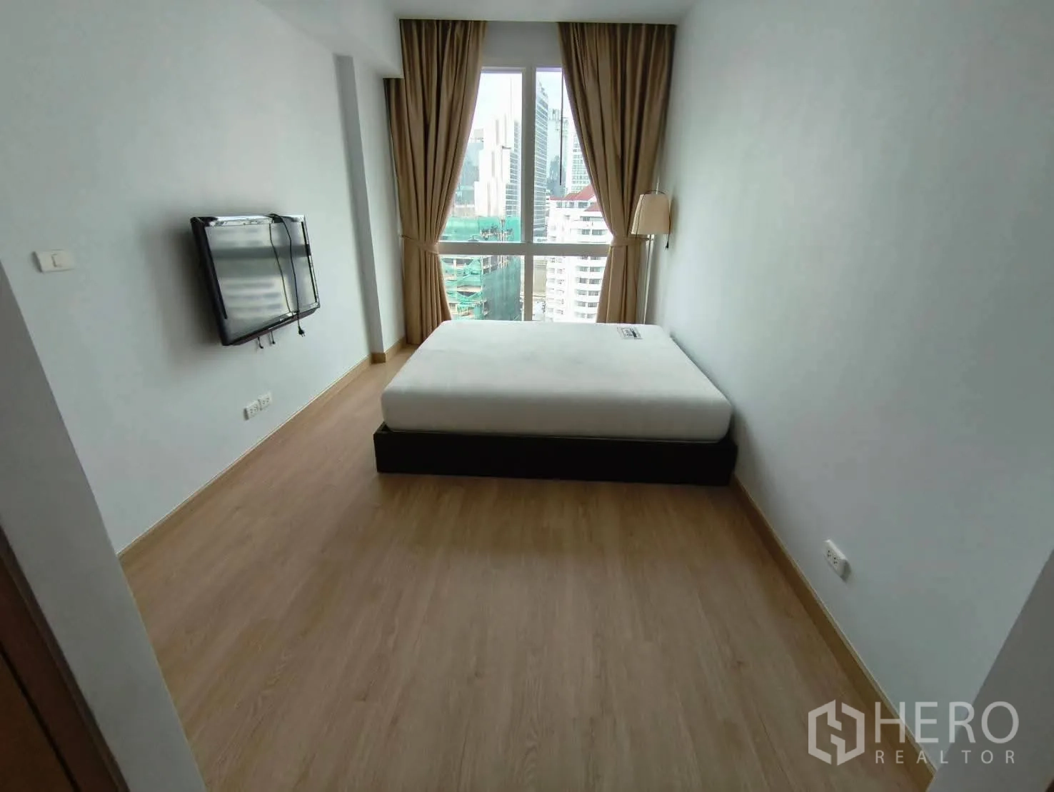 คอนโด ให้เช่าในKhlong Toei, Bangkok - ห้องนอนหลัก หน้าต่างวิวเมือง เตียงคู่ ทีวีติดผนัง และผ้าม่านสีเบจ