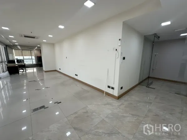 Office Space for rent - Open-plan office with tiled floors, recessed lighting and a glass partition.