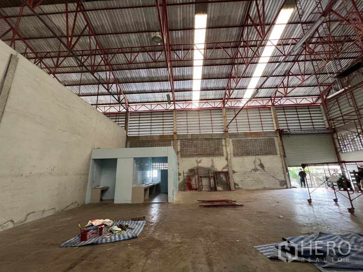 คลังสินค้า ให้เช่าในKhlong Sam Wa, Bangkok - พื้นที่ผลิตโล่ง มีมุมโต๊ะทำงานและทางเข้าออกประตูม้วน