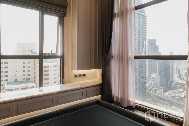 Condominium for rent or sale in Watthana, Bangkok - Corner bedroom with wraparound windows, Bangkok skyline views and built‑in window seat.