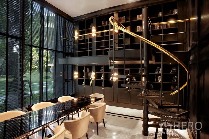Condominium for rent in Pathum Wan, Bangkok - Double-height library and co-working space with a spiral staircase, wall of bookshelves and garden views.