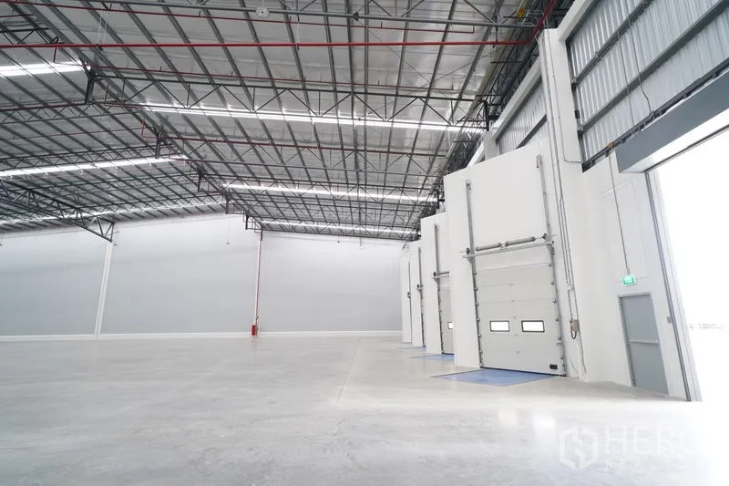 Warehouse for rent in Khlong Luang, Pathum Thani - Multiple loading docks with insulated roll-up doors and dock levelers inside the warehouse.