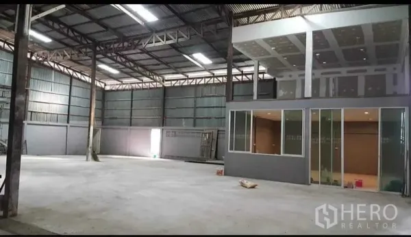 Warehouse for rent in Sai Noi, Nonthaburi - High‑ceiling warehouse interior with concrete floor and glass-fronted office
