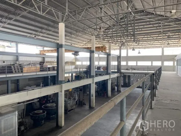 Factory for sale in Khlong Luang, Pathum Thani - High-clearance production hall with steel trusses and mezzanine walkways.