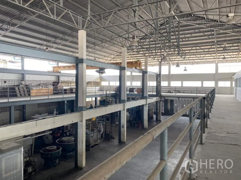 Factory for sale in Khlong Luang, Pathum Thani - High-clearance production hall with steel trusses and mezzanine walkways.