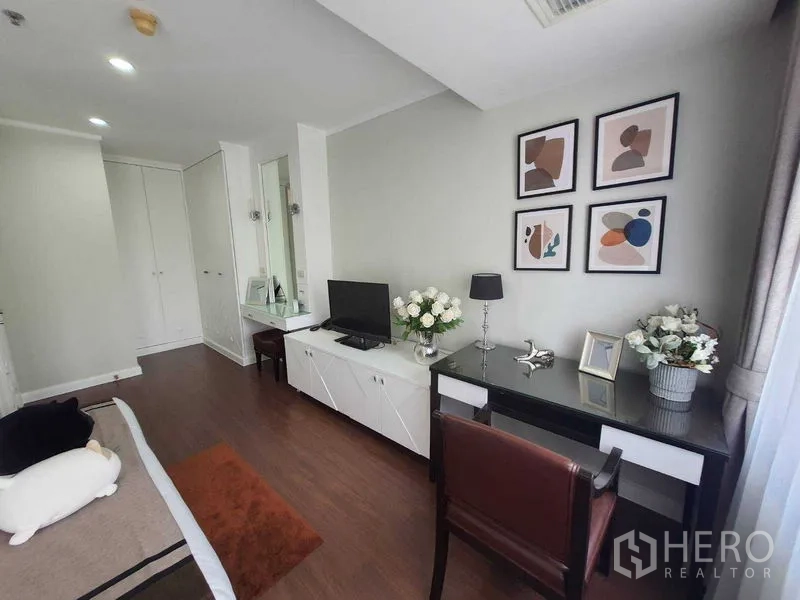 อพาร์ทเมนท์ ให้เช่าในWatthana, Bangkok - มุมทำงานในห้องนอน มีโต๊ะทำงาน ตู้ทีวี กรอบภาพ และแจกันดอกไม้