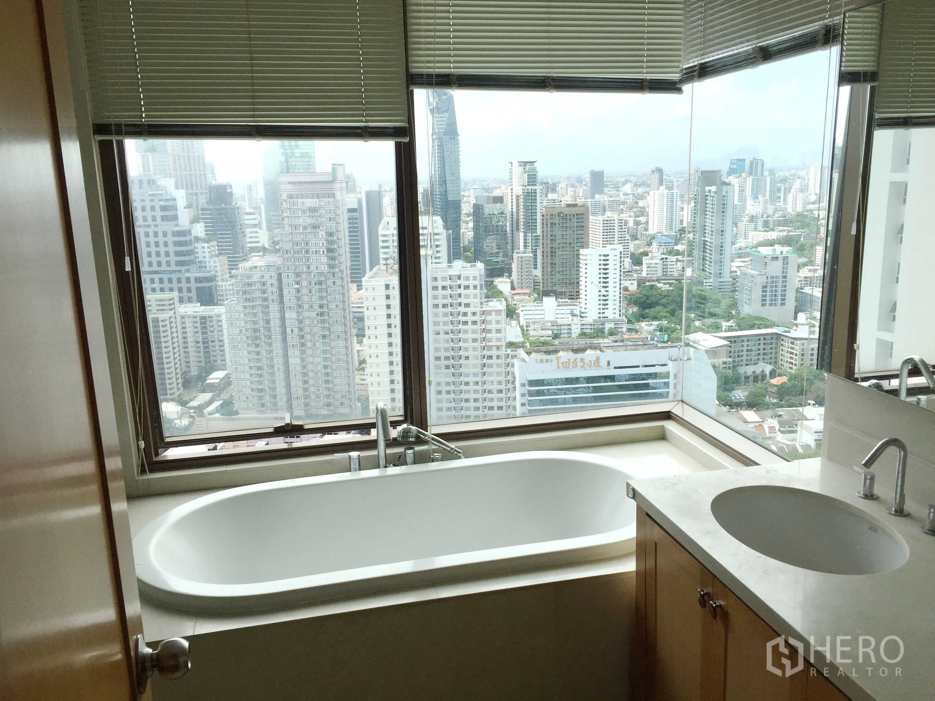 คอนโด ให้เช่าในKhlong Toei, Bangkok - ห้องน้ำพร้อมอ่างอาบน้ำติดมุมหน้าต่าง มองวิวเมืองกรุงเทพฯ และเคาน์เตอร์ท็อปหิน