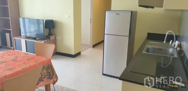 คอนโด ให้เช่าในKhlong Toei, Bangkok - ครัวขนาดกะทัดรัด เคาน์เตอร์สีดำ ซิงก์ เตาไฟฟ้า ตู้เย็น และโต๊ะทานข้าว