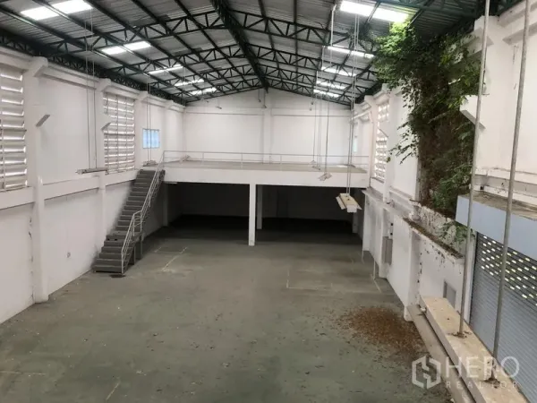 工厂 出租或出售在Bang Lamung, Chon Buri - 高挑仓库内景，带夹层、钢结构屋架和侧边楼梯。