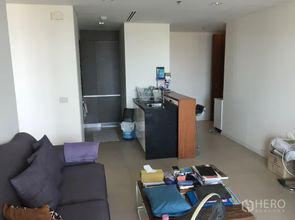 คอนโด ให้เช่าหรือขายในKhlong San, Bangkok - พื้นที่นั่งเล่นแบบโอเพ่นแพลนพร้อมโซฟาและครัวพร้อมเคาน์เตอร์บาร์ ในคอนโดสมัยใหม่