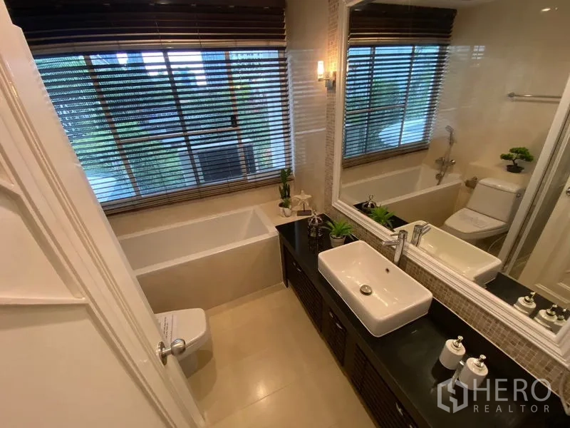 อพาร์ทเมนท์ ให้เช่าในWatthana, Bangkok - ห้องน้ำพร้อมอ่างอาบน้ำ กระจกบานยาวและเคาน์เตอร์อ่าง มองเห็นวิวสีเขียวจากหน้าต่าง