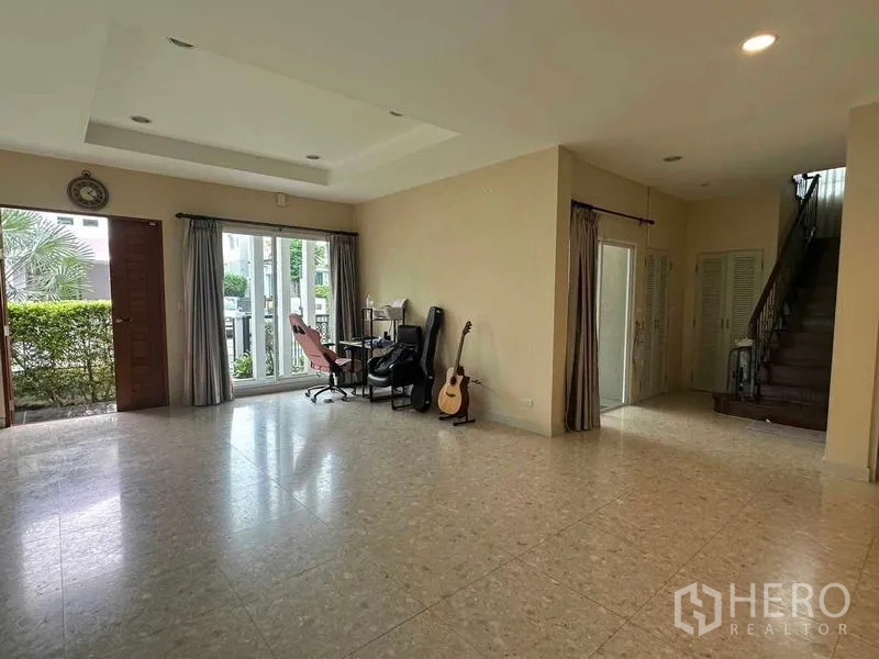 Detached House for sale in Saphan Sung, Bangkok - Bright living area with sliding doors to the garden and stairs to the upper floor.