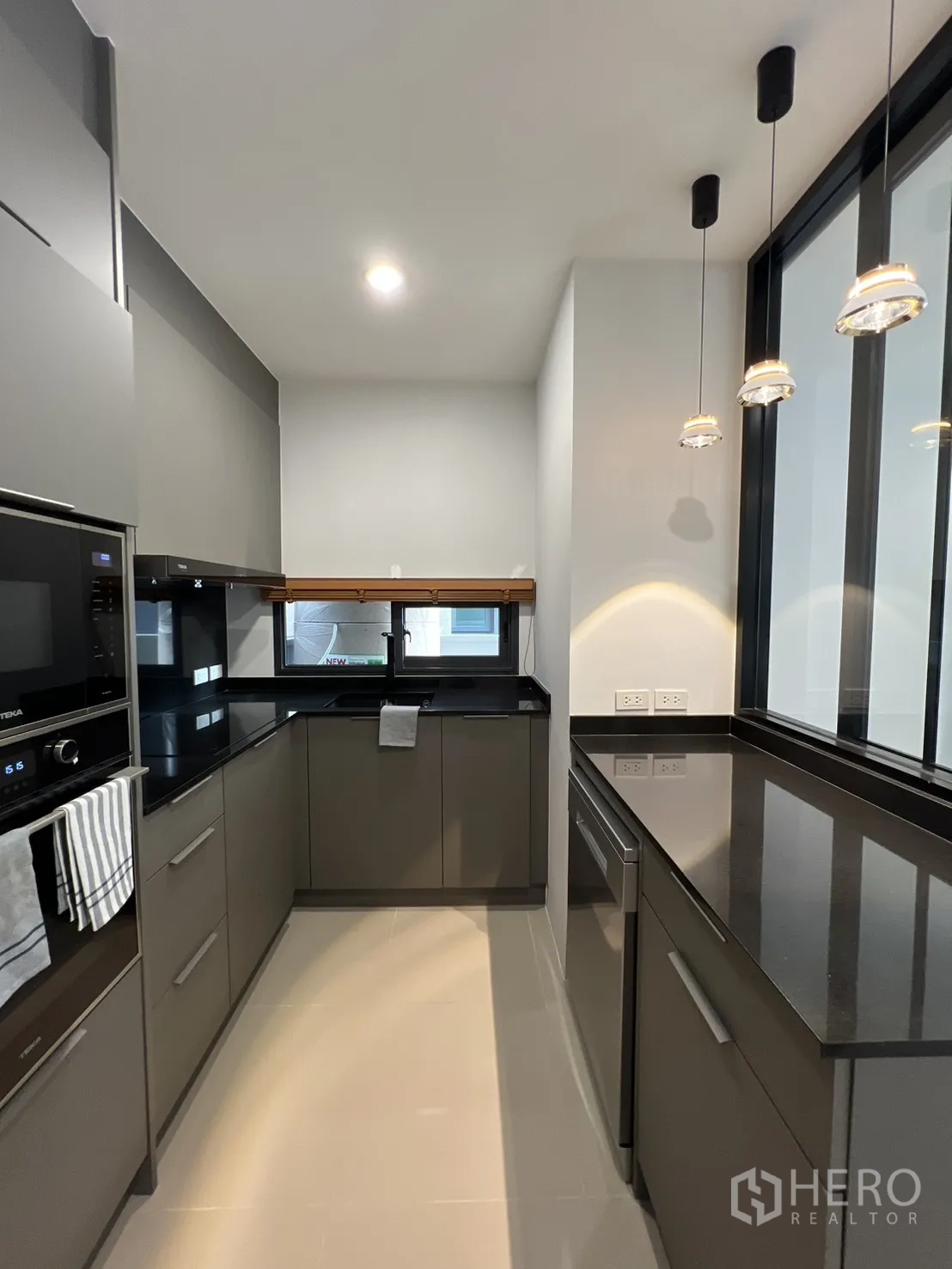 Detached House for rent in Prawet, Bangkok - Compact U-shaped kitchen with window and ample storage.