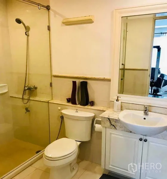 Condominium for rent in Khlong Toei, Bangkok - Bright bathroom with glass-enclosed shower, vanity and toilet in a modern Khlong Toei condo.