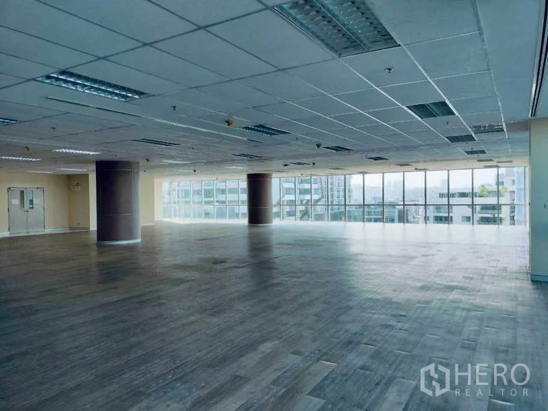 Office Space for rent in Sathon, Bangkok - Large empty office with panoramic glazing, city views and a suspended grid ceiling with lighting.