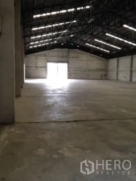 Warehouse for rent in Nakhon Pathom - Wide warehouse space showing high-clearance ceiling and bright access doors at both ends.