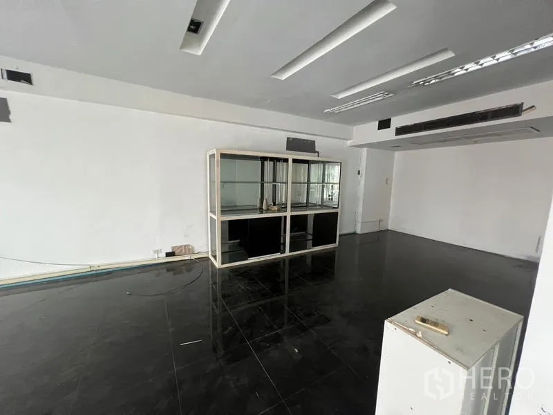 零售空间 出租在Watthana, Bangkok - 零售单元设有立式玻璃展示柜与吊顶照明，黑色光面地砖。