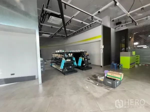 พื้นที่ขายปลีก ให้เช่า - พื้นที่ค้าปลีกมีชั้นวางสินค้า พื้นกระเบื้อง ไฟราง และเคาน์เตอร์บริการพร้อมใช้งาน.