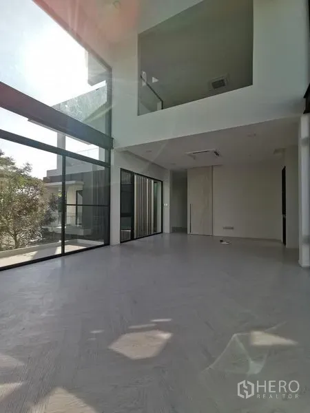 Detached House for sale in Saphan Sung, Bangkok - Sunlit double-height living room with floor-to-ceiling windows and open space.